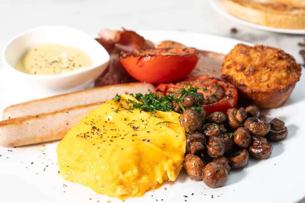 Scrambled eggs with bacon, mushrooms, hash brown and toast