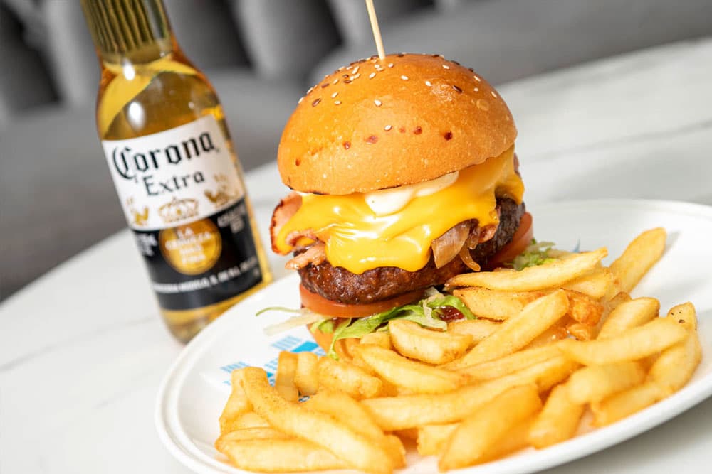 A cheeseburger with fries and an ice-cold Corona